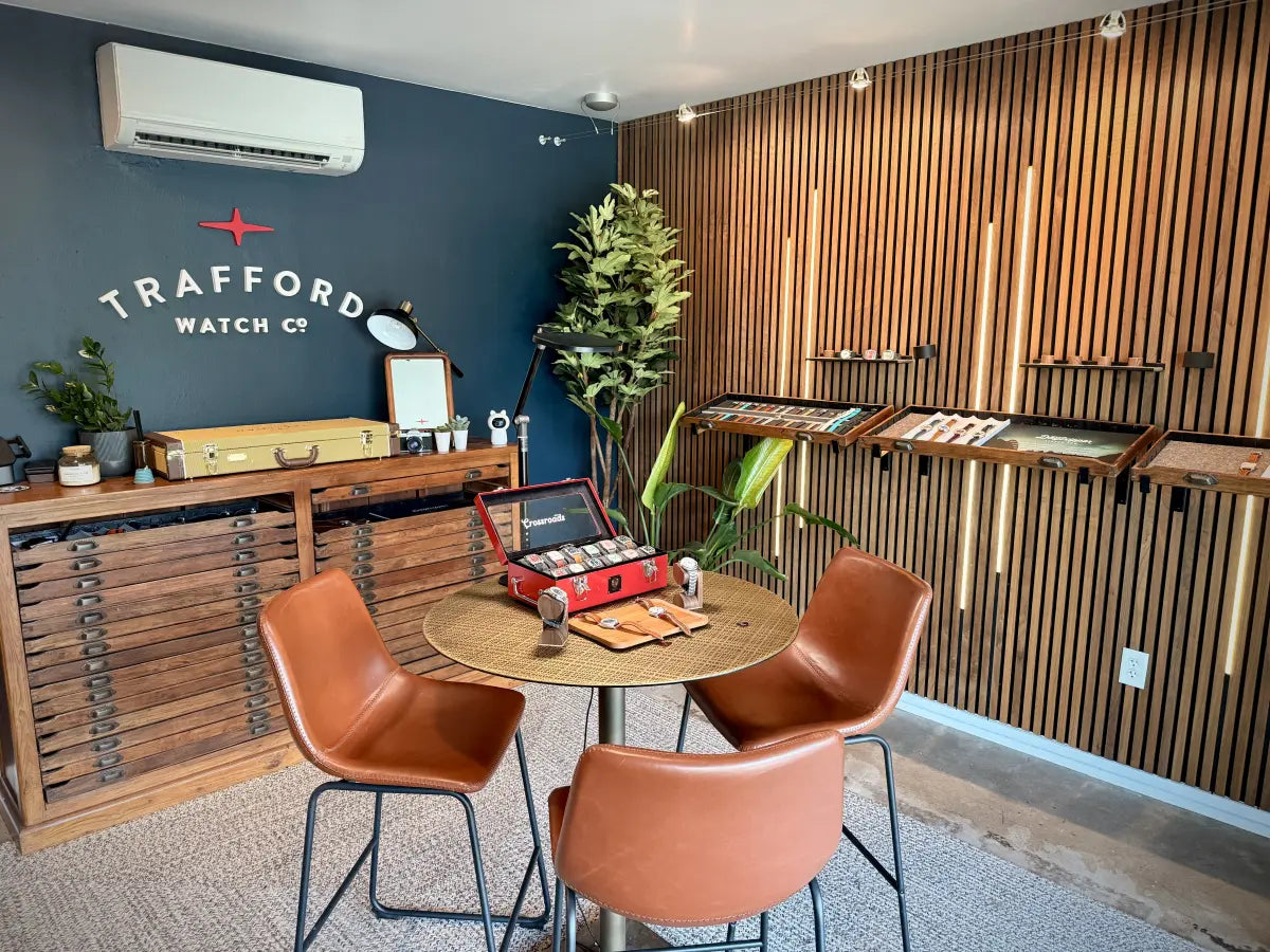Inside the Trafford Watch Co. showroom: watches and straps displayed on the slatted wall beside a seating table